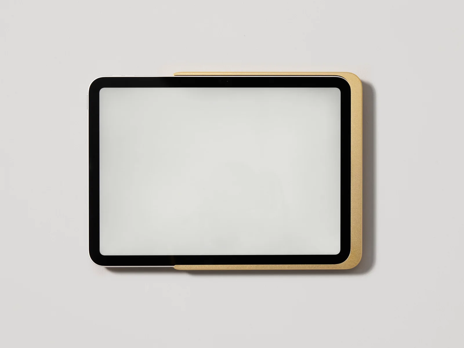 Displine Dame Wall Home 2.0 in gold anodised aluminium, holding an iPad