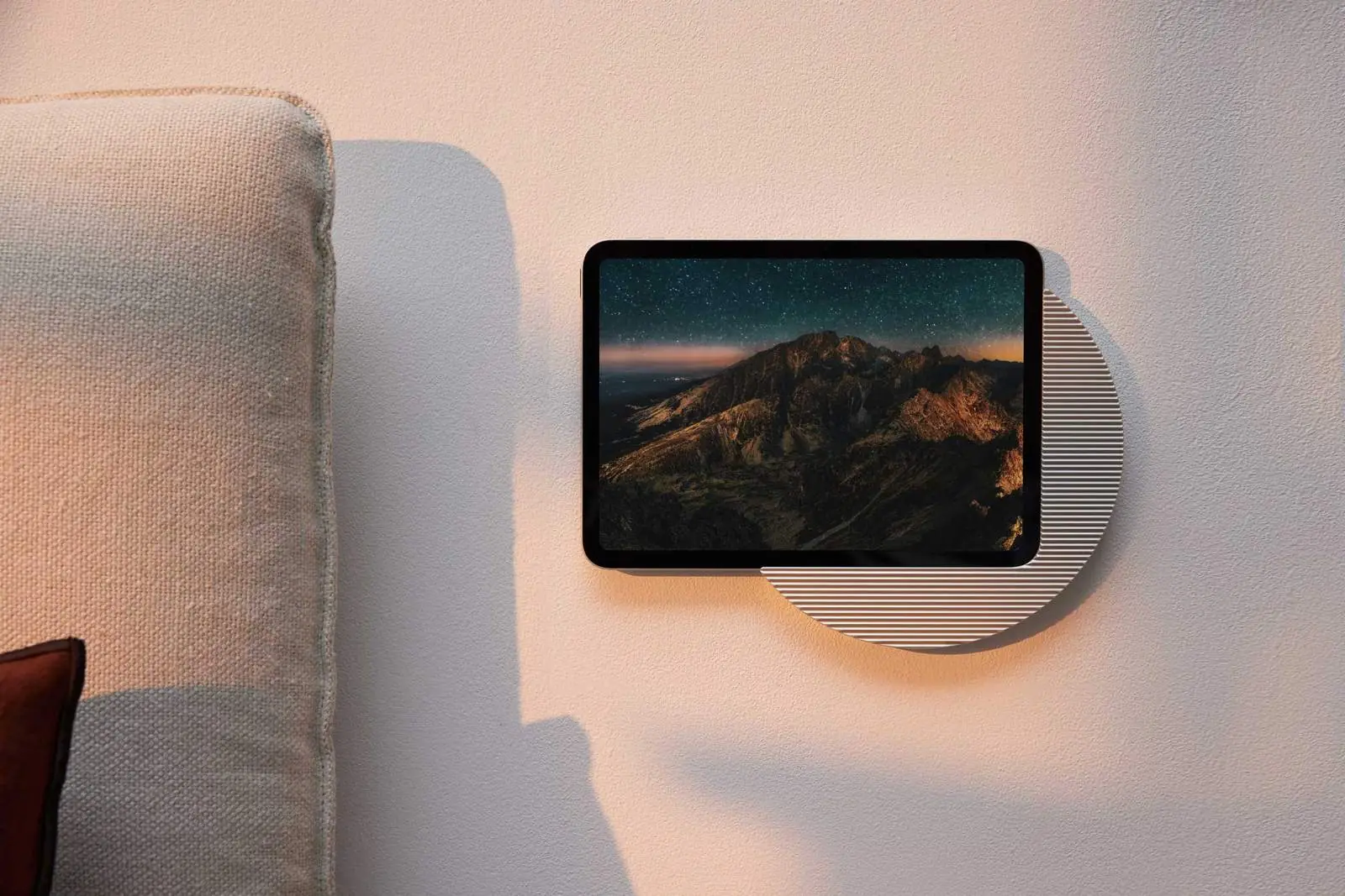 Tablet in a round Displine wall mount beside a sofa
